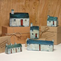 five ceramic houses are sitting in boxes on the table