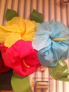 colorful paper flowers sitting on top of a table