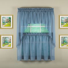 a window with blue curtains and pictures on the wall