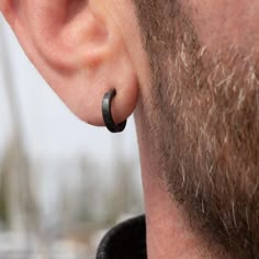 a close up of a person wearing ear rings and looking at something in the distance