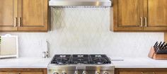 a stove top oven sitting inside of a kitchen next to wooden cabinets and counter tops