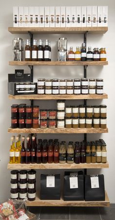 the shelves are filled with different types of spices and condiments on wooden shelves