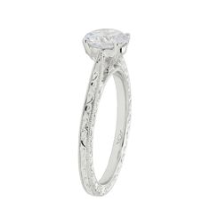 a white gold engagement ring set with an oval cut diamond and filigrees