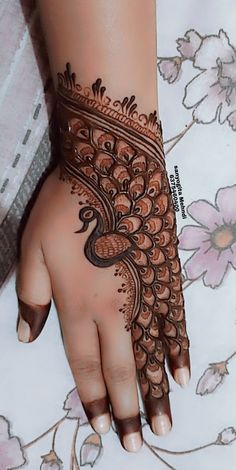 a woman's hand with henna tattoos on it