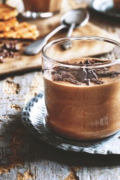 a glass jar filled with chocolate pudding on top of a wooden table