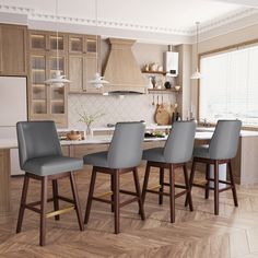 a kitchen with wooden floors and gray chairs