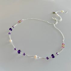 Genuine, premium-rated, mixed gemstone choker/necklace, wire wrapped in sterling silver This dainty yet colourful, all-gemstone choker/necklace, is hand-crafted with genuine, premium-rated, peridot, amethyst, pink topaz gemstones and freshwater pearls.  These gemstones are artfully positioned and meticulously wire-wrapped to create a focal segment, measuring approx. 6 inches.  A beautiful combination of coloured gemstones of purple, pink, green and creamy white pearls, with sizes ranging from 3.5 to 5.5 mm; this necklace is finished with sterling silver chain and clasp. While not quite evident in the photos, the micro-faceting and translucency of these premium-rated gemstones add much sparkle and shine to this choker/necklace.   Please note this necklace has been enlarged to show details. Dainty Natural Stone Choker Necklace, Delicate Sterling Silver Necklaces With Natural Stones, Purple Sterling Silver Necklace With Adjustable Chain, Delicate Sterling Silver Necklace With Natural Stones, Dainty Amethyst Jewelry With Delicate Chain, Dainty Amethyst Necklaces With Natural Stones, Dainty Silver Crystal Choker Necklace, Handmade Dainty Amethyst Necklace, Dainty Sterling Silver Birthstone Necklace