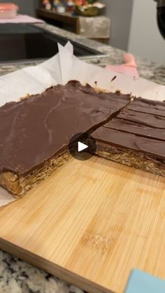 two pieces of chocolate sitting on top of a wooden cutting board