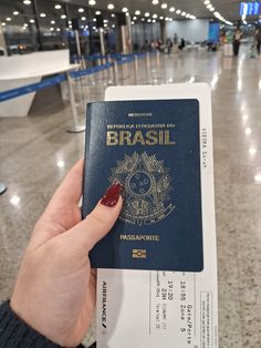 a person holding up a passport in an airport