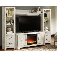 a living room with a fireplace and entertainment center in whitewash wood, featuring an entertainment center built into the wall