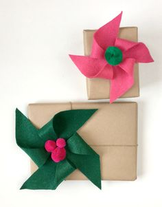 two pieces of paper with flowers on them sitting next to each other in front of a present box