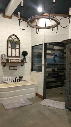 a bath room with a tub a mirror and lights