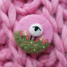 a close up of a pink knitted object with a sheep on it