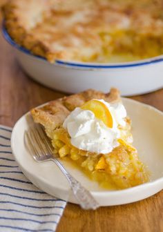 a piece of pie on a plate with a fork next to it and another pie in the background