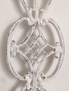 a decorative white wall hanging on the side of a building with an intricate design in it