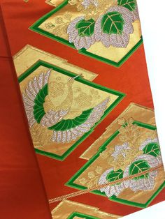 A long vintage Japanese Obi Belt for Kimono robe.  Orange silk Obi sash with vivid green, metallic gold and silver Crane bird and floral crests.   International Express Shipping includedsee below) MATERIAL:  Silk with metallic design.  COLOR:  Orange, green, metallic gold & silver. PATTERN: Crane bird and floral crest. CONDITION: Used, vintage.  Good condition (see photo).   SIZE:  Same width through out. Length: 164 inches (416 cm).  Wide width: 12 inches (30.5 cm). Length of pattern: 106.5 inc Traditional Gold Kimono For Festive Season, Traditional Gold Kimono For Festive Occasions, Japanese Obi Belt, Obi Sash, Japanese Obi, Japanese Crane, Metallic Design, Wedding Sash Belt, Crane Bird