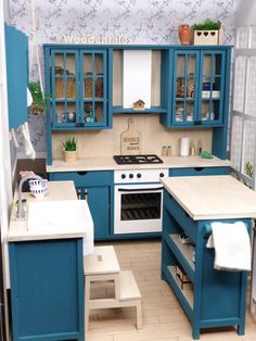 a model kitchen with blue cabinets and white counter tops, including an oven and sink