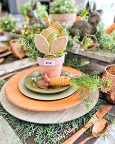 a table setting with carrots and flowers in pots on top of each plate, along with other place settings