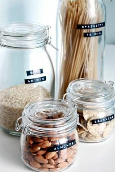 three glass jars filled with different types of nuts and pastasticks in front of each other