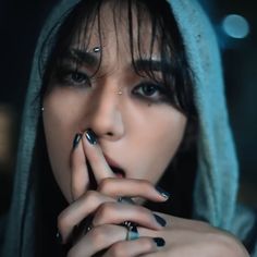 a woman with black nails and piercings on her face is posing for the camera