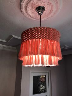 a red chandelier hanging from the ceiling in a room with a door and window