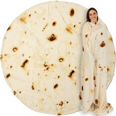 a woman standing next to a large tortilla