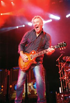 a man with an electric guitar on stage