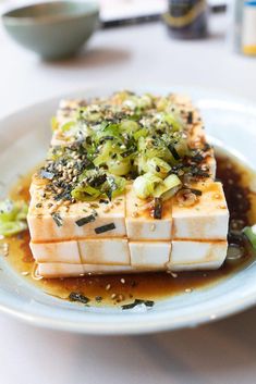 a white plate topped with tofu covered in sauce