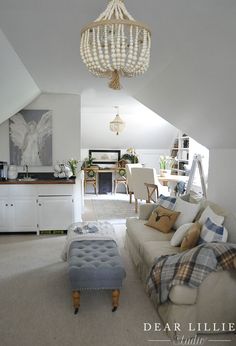 a living room filled with furniture and a chandelier hanging over the top of it