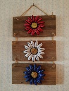 three wooden wall hangings with red, white and blue flowers on them in the shape of sunflowers