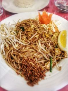 a white plate topped with noodles and meat