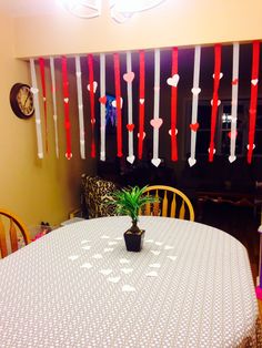 a table with a potted plant sitting on top of it next to some red and white streamers