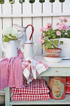 a table with flowers and watering cans on it