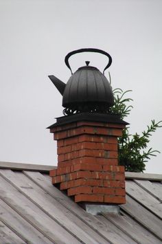 a tea pot on top of a brick chimney