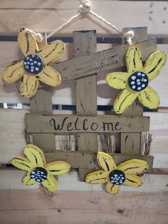 a welcome sign made out of wooden pallets with painted flowers on the front and back