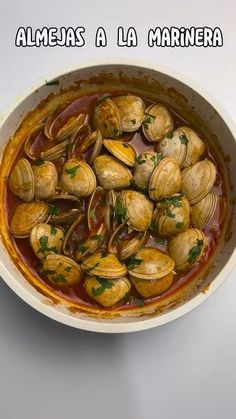 a white bowl filled with clams and sauce