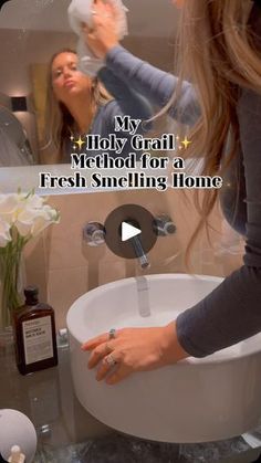 a woman is washing her hands in the bathroom sink while another woman looks at her reflection