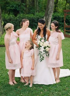 a group of women in pink dresses standing next to each other