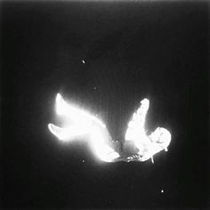 a black and white photo of a person falling off their skis in the dark