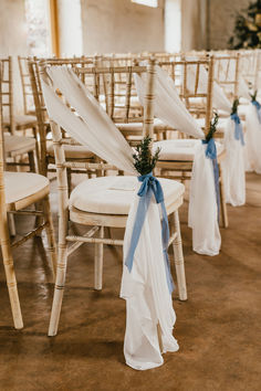 the chairs are decorated with blue ribbons and flowers