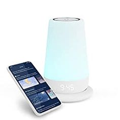 an alarm clock and cell phone next to it on a white surface with a blue light