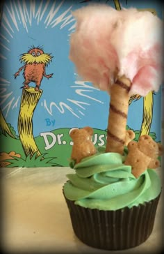 a cupcake with green frosting and a dr seuss tree on top