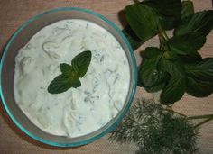 a bowl of yogurt next to some green leaves