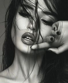 a black and white photo of a woman with her hands on her face