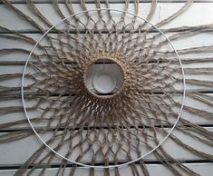 a circular object made out of rope on top of a wooden table with white boards