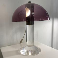 a purple lamp sitting on top of a white table