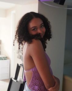 a woman with curly hair and a beard standing in front of a kitchen counter top