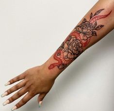 a woman's arm with a rose and snake tattoo on it