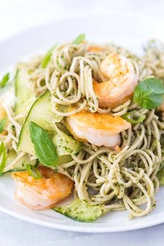 pasta with shrimp, zucchini and pesto sauce on a white platter