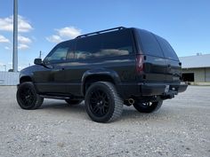 a black suv is parked in an empty lot